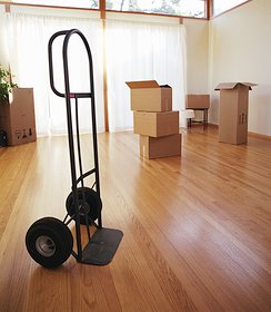 an empty moving dolly in the middle of a living room with boxes